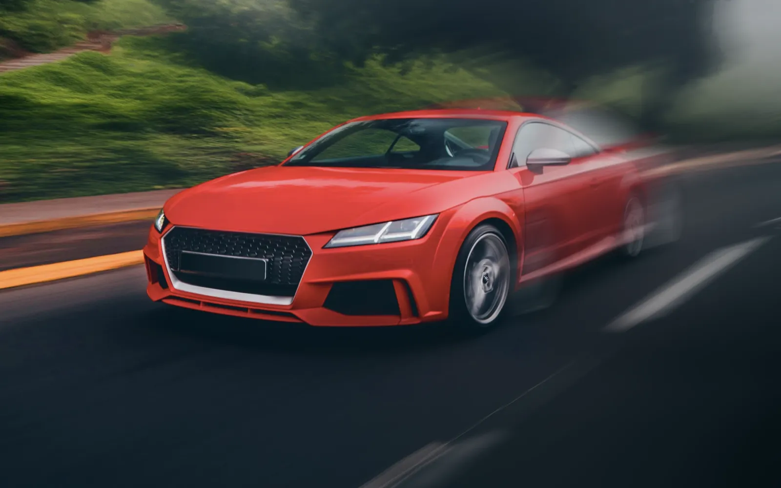 A red sports car oon the roadway.